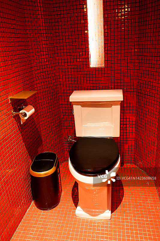 红色浴室中的黑白马桶图片素材