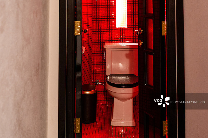 红色浴室中的黑白马桶图片素材