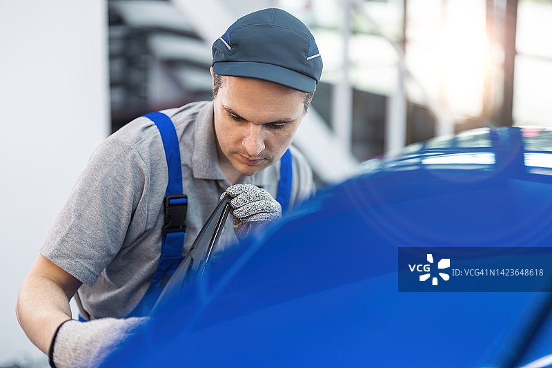 汽车美容服务中检查绘画和抛光工作的技师图片素材