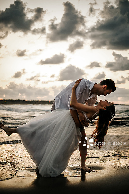 海滩上的新婚夫妇剪影（婚礼概念）图片素材