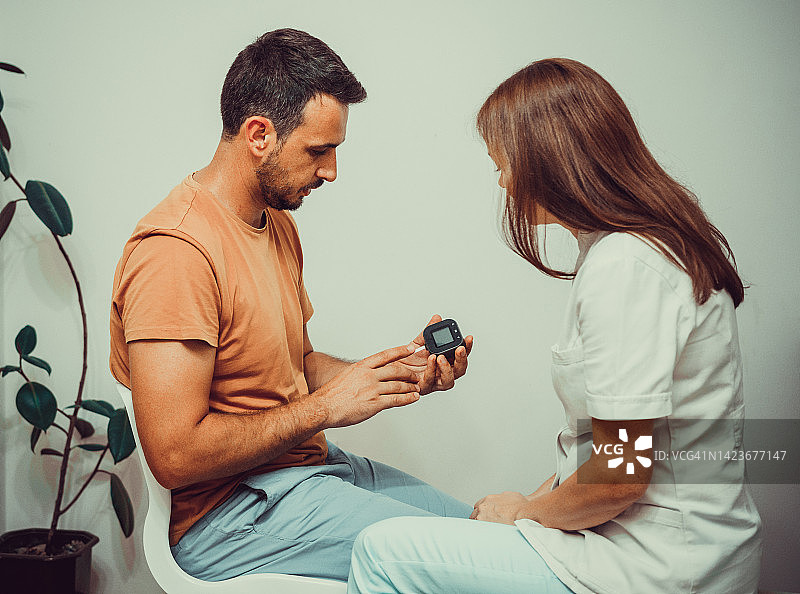 女医生为病人进行血糖测试图片素材