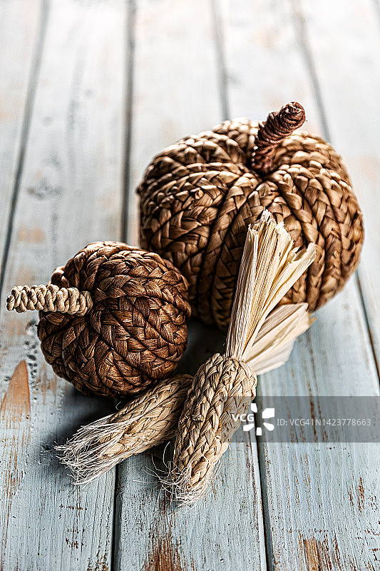 蓝色木纹背景上的秋季粗花呢南瓜和玉米图片素材