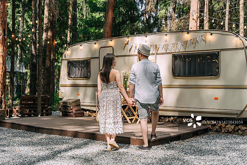 夏日里，年轻情侣在露营拖车旁图片素材