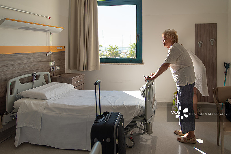 站在养老院床边的年长女人图片素材