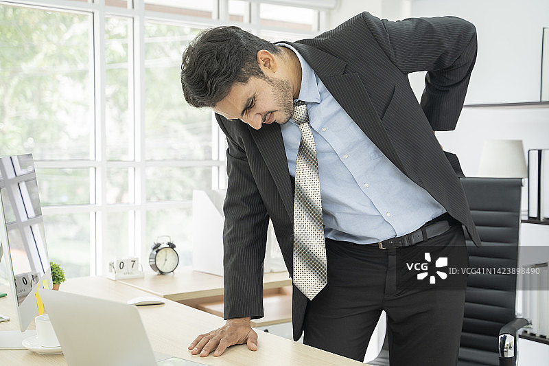 痛苦地扶着背的商人图片素材