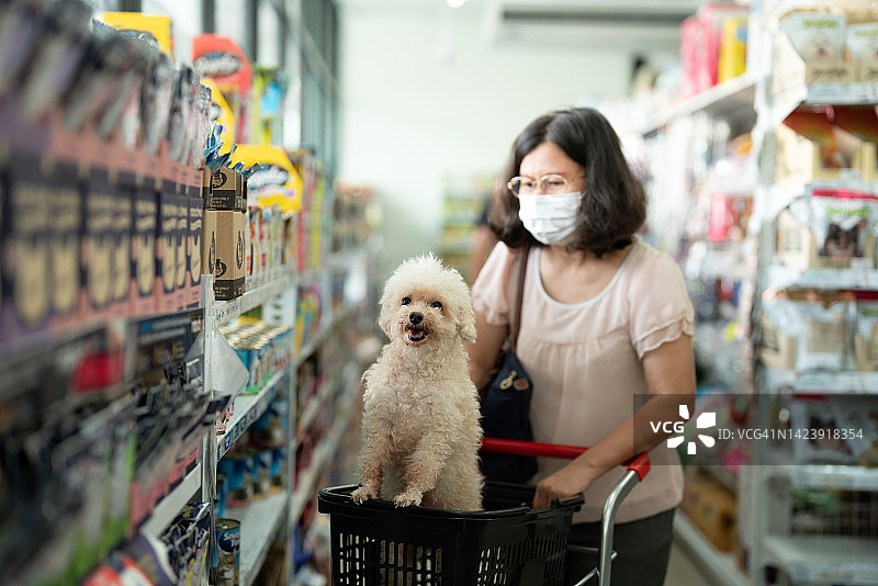 女人和贵宾犬在宠物店购物图片素材