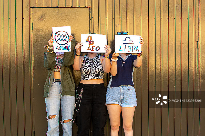 三个年轻女人拿着十二星座标志图片素材