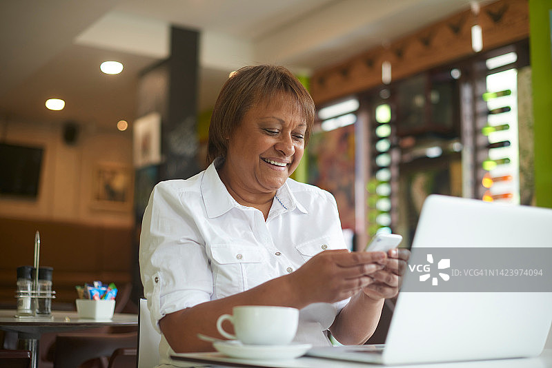 店主、员工和经理在咖啡馆通过手机阅读邮件，计划餐厅订单，并在社交媒体上进行在线交流。快乐的黑人女性在小企业管理层工作。图片素材