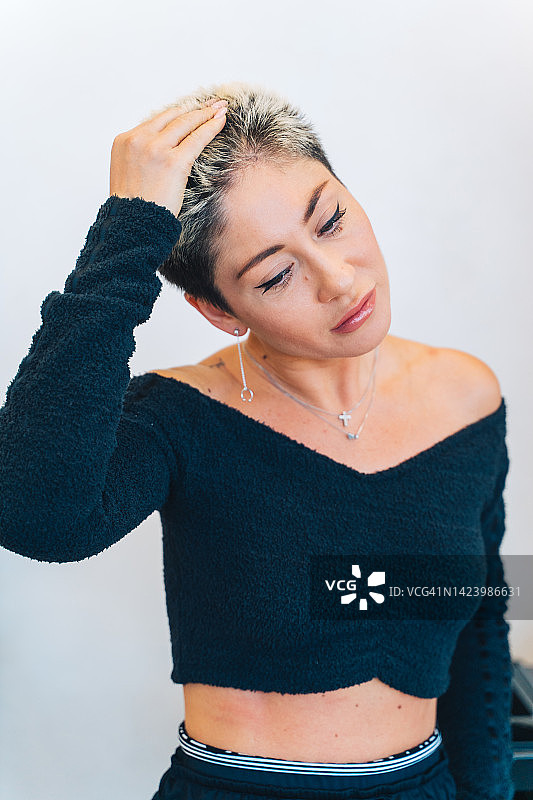 护发：在美容院理发后，女子愉悦地触摸头发图片素材