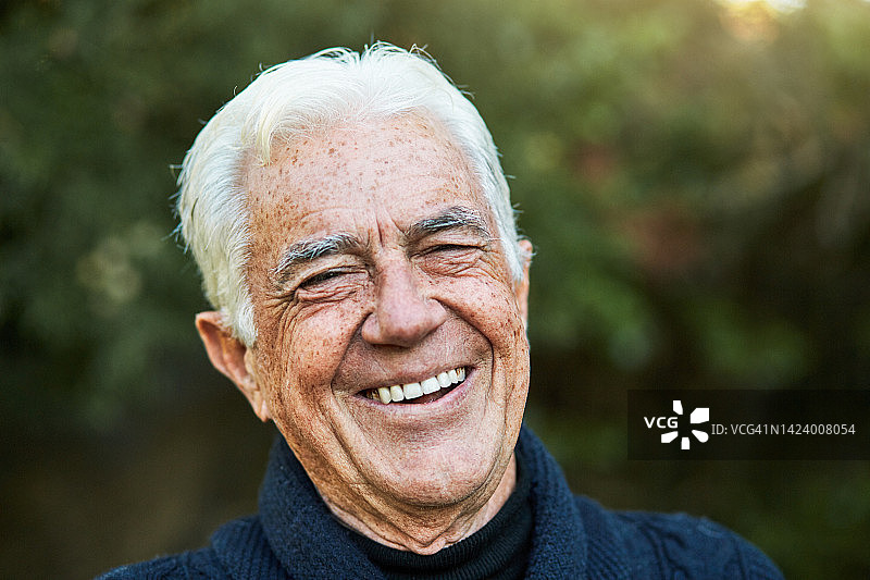 在绿叶花园户外快乐微笑的白发老人图片素材