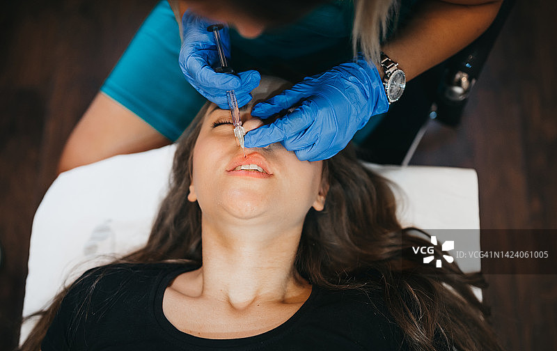 女人在嘴唇附近注射肉毒杆菌进行美容图片素材