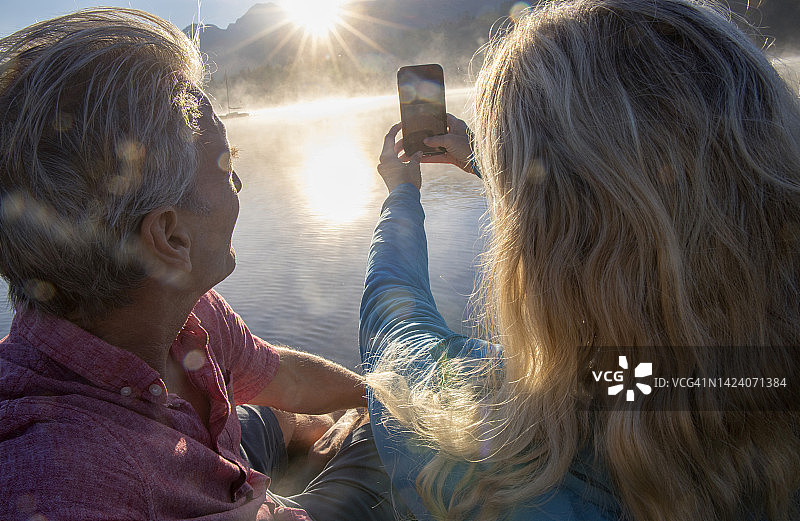 年长夫妇拍摄湖上日出和雾气图片素材
