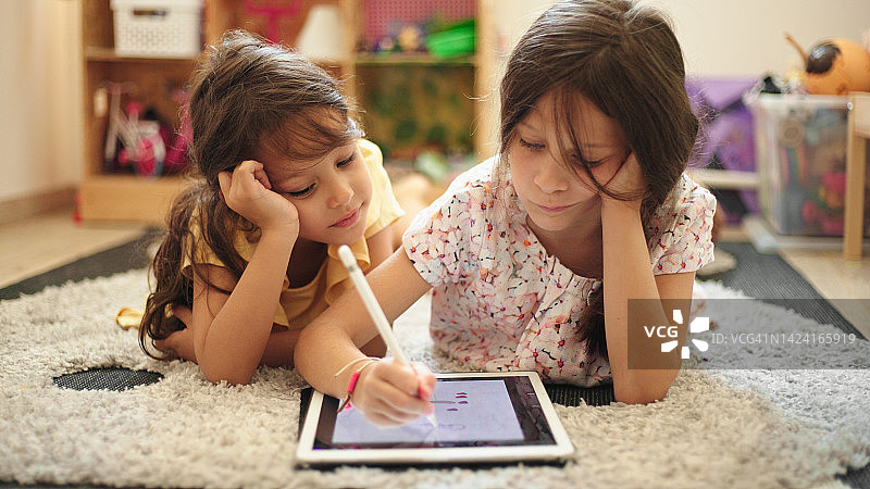 两个姐妹在家使用数位板和数字化笔绘画图片素材