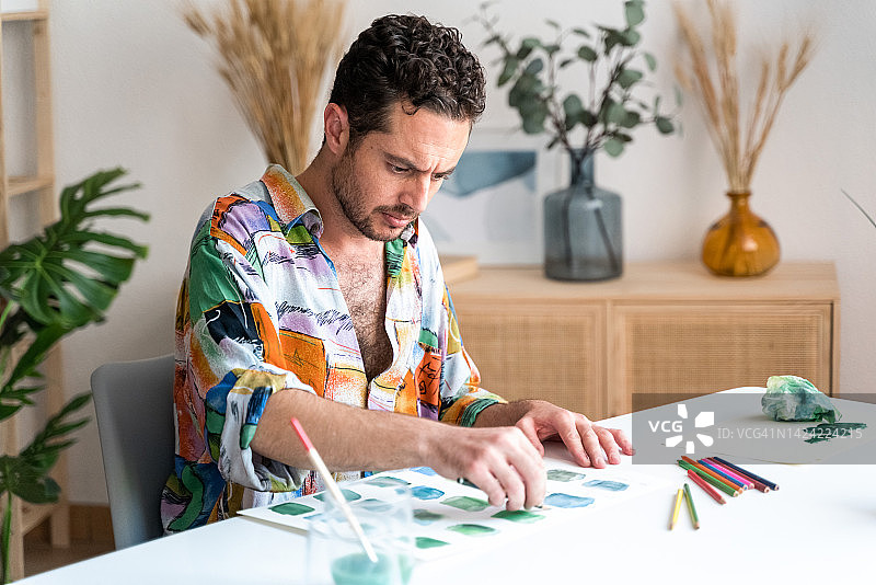 男人在水彩颜料上用铅笔绘画图片素材