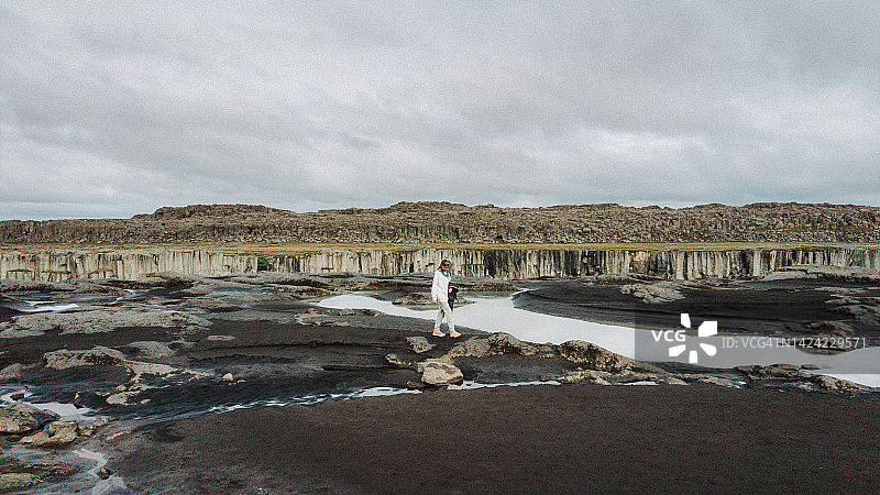 青少年在泥泞的悬崖边，戴着头网在河边行走图片素材