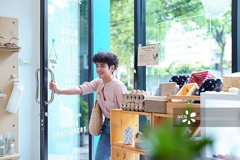 女人打开门进入商店购物图片素材