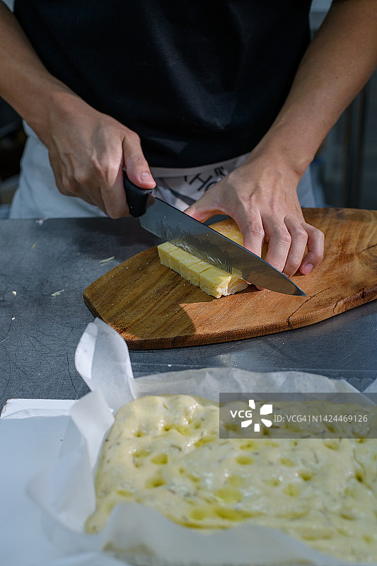 厨师切帕尔马干酪，用于烘烤意式薄饼图片素材