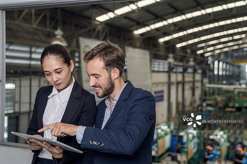 在工厂里与女商人交谈的商人图片素材