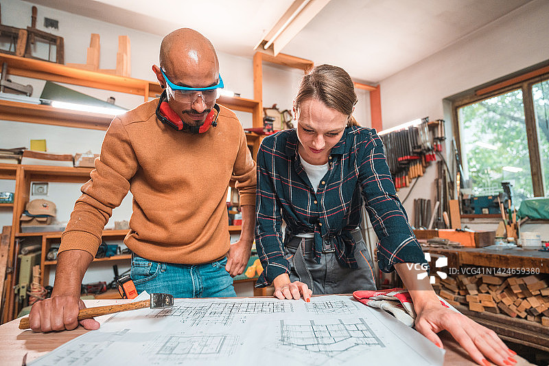 使用防护装备查看蓝图的男女木匠图片素材