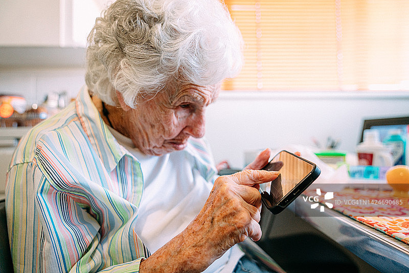 年长的白人妇女在智能手机上用食指进行电子签名图片素材