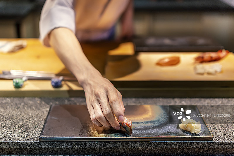 厨师把寿司放在盘子里的特写图片素材