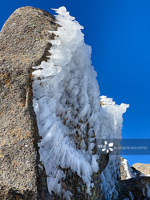 阳光下冻结在岩石上的冰图片素材