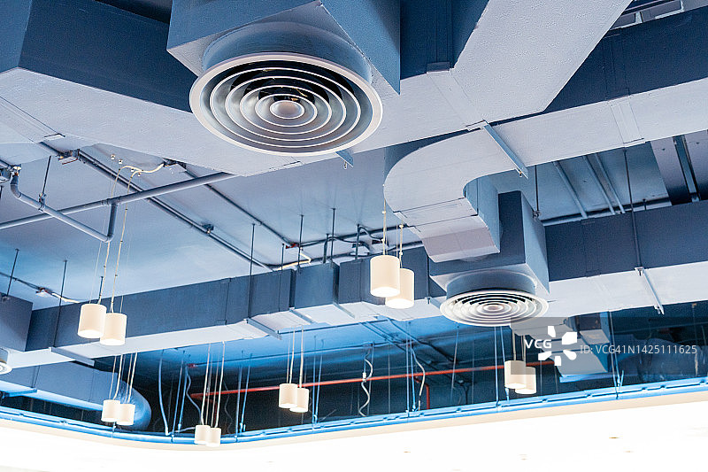 裸露的天花板、通风管道、监控摄像头、空调管道和消防喷淋系统图片素材