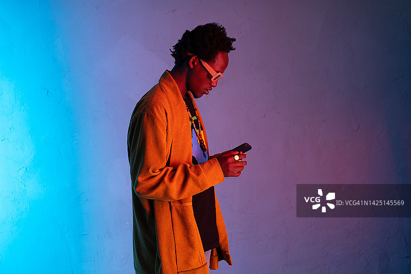 盯着智能手机的非洲男人图片素材