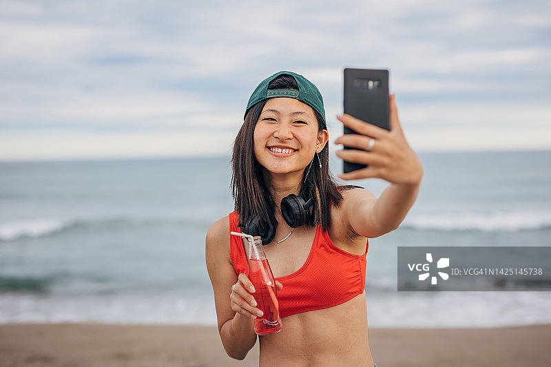 在海滩自拍的年轻中国女人图片素材
