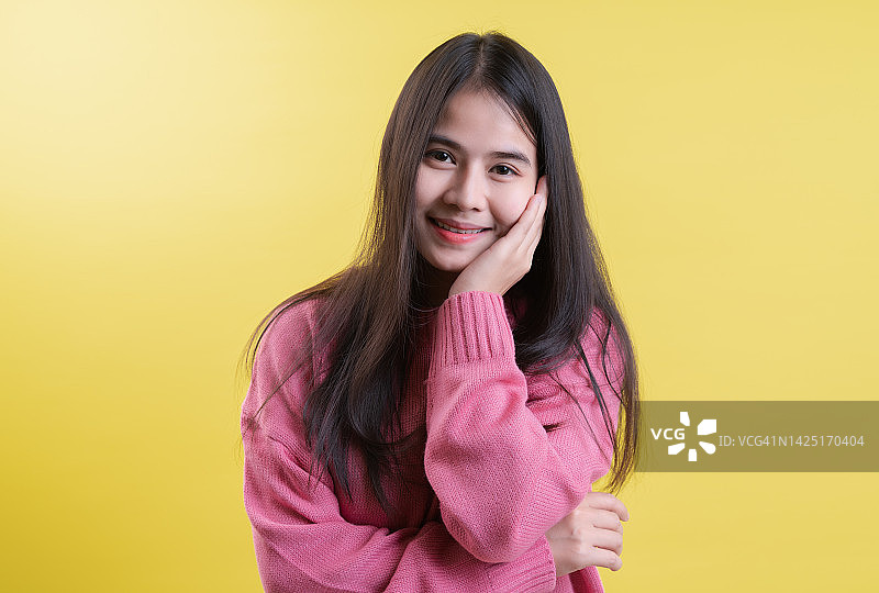 托着下巴的年轻女性感到无聊的肖像，黄色背景图片素材