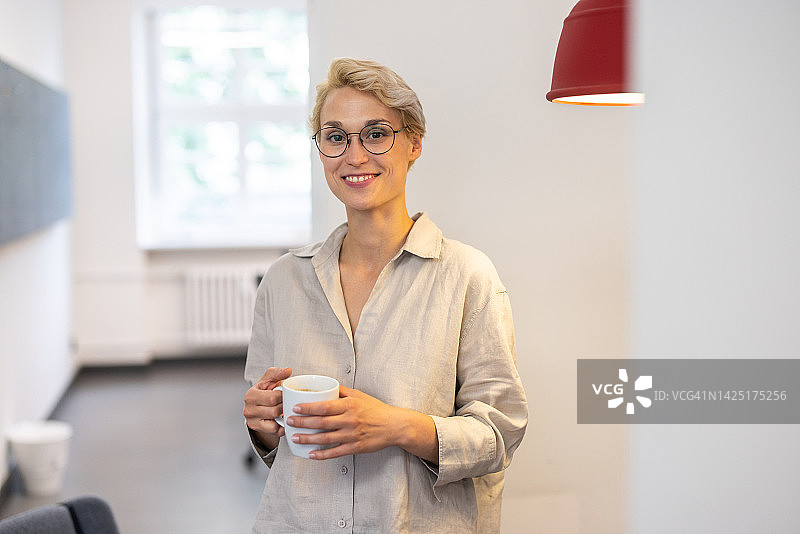 快乐的女商人在创业办公室进行咖啡休息交谈图片素材