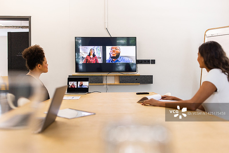 两位同事在创业公司通过视频通话与团队讨论图片素材