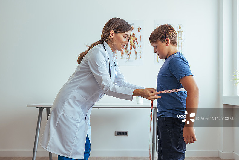 营养师在办公室咨询期间测量患者的腰围图片素材