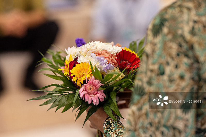 特写：女人在研讨会上手捧鲜花图片素材