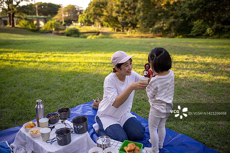 女儿在公园里给妈妈倒茶图片素材