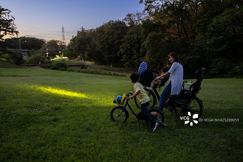 在公园玩耍后骑自行车回家的家庭图片素材