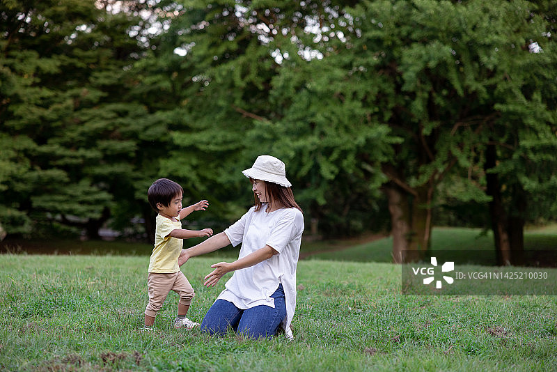 小男孩走向在公园里的母亲图片素材