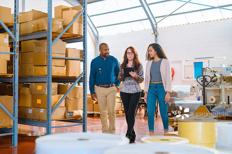 仓库、工厂或车间内工作的经理及其团队的运输、电子商务和物流。出口和进口行业的合作与团队合作，以实现货运和货物交付图片素材