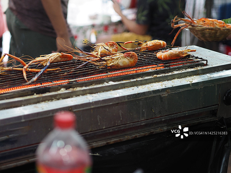 男人用电炉烤虾图片素材