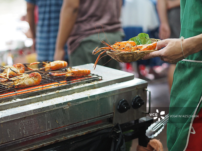 男人用电炉烤虾图片素材