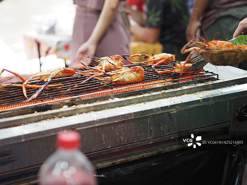 男人用电炉烤虾图片素材