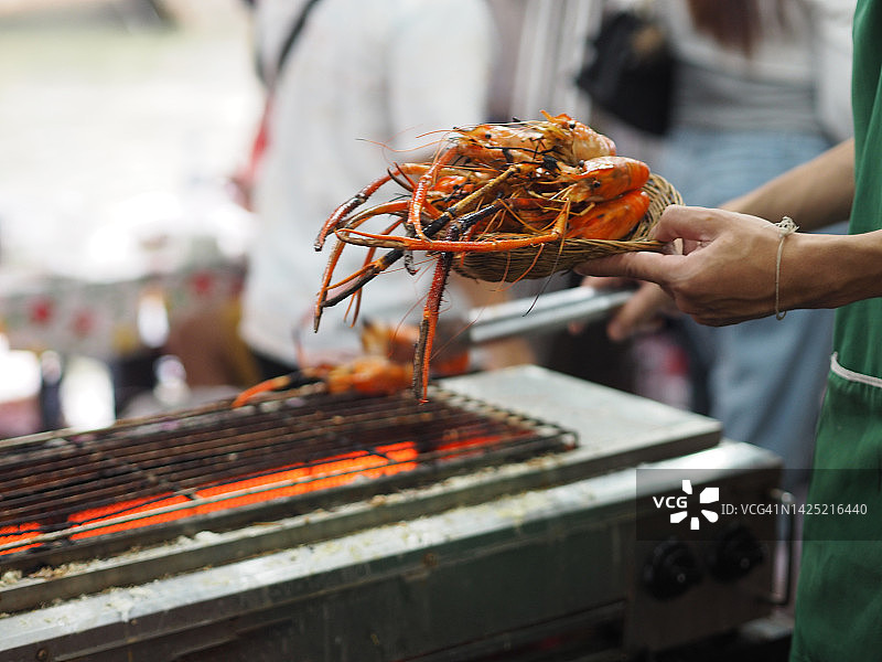 男人用电炉烤虾图片素材