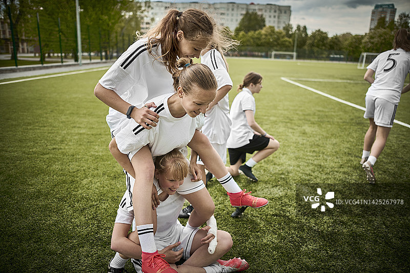 嬉戏的少女足球队搭建人体金字塔图片素材