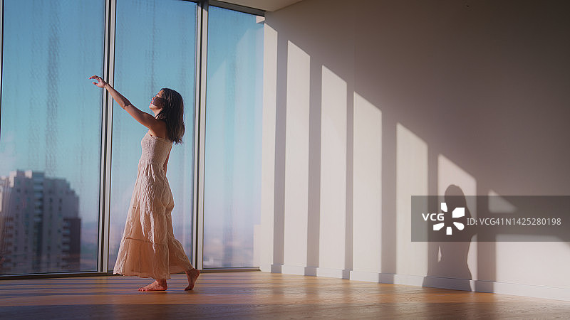 阳光下快乐起舞的年轻亚裔女性图片素材