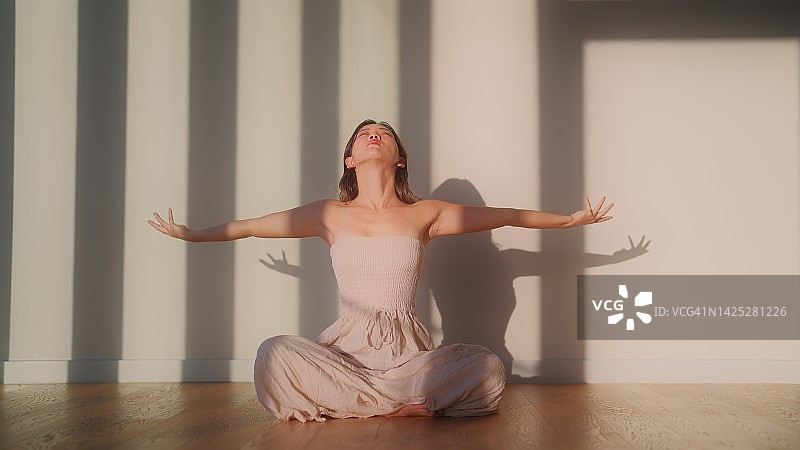 阳光下，年轻女子在房间里冥想图片素材