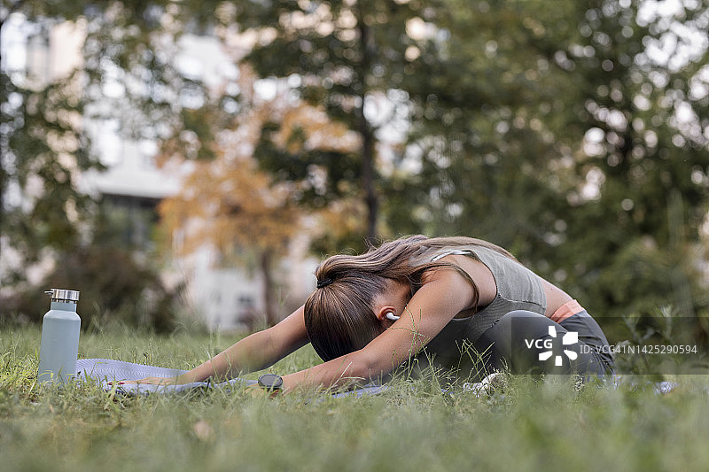 年轻运动的女人练习瑜伽，做儿童式，Balasana姿势，在户外锻炼图片素材