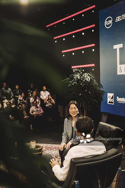 会议活动中，微笑的面试官与科技企业家互动图片素材