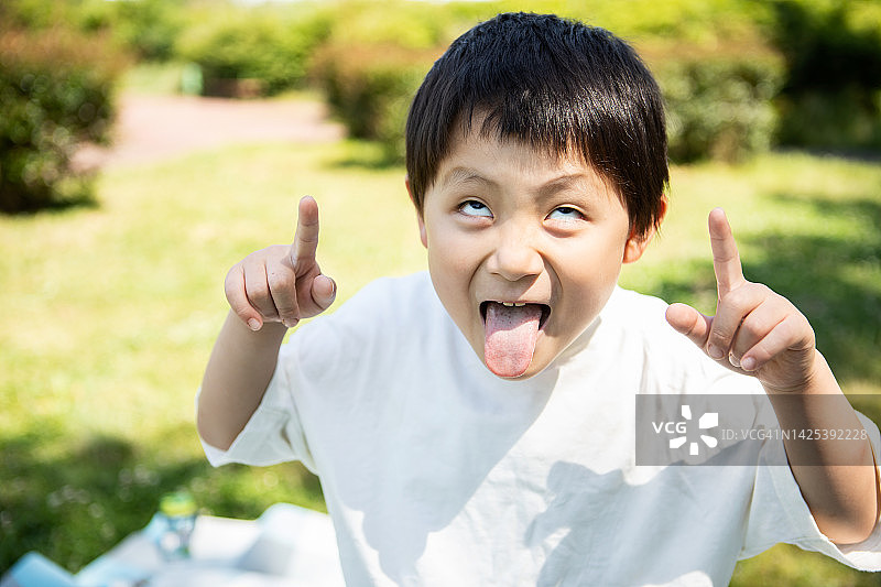5岁男孩做着鬼脸玩耍图片素材