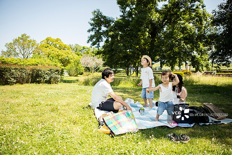日本家庭在春天公园里享受野餐图片素材