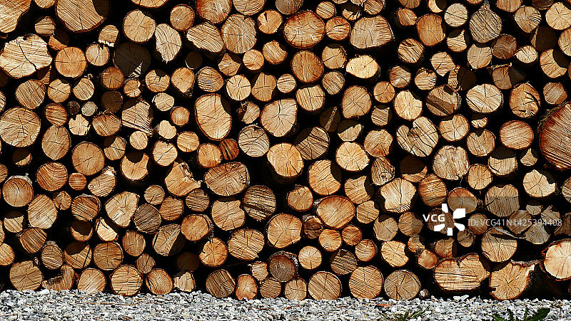 堆叠的原木，用作柴火和砾石，位于法国埃维昂莱班图片素材